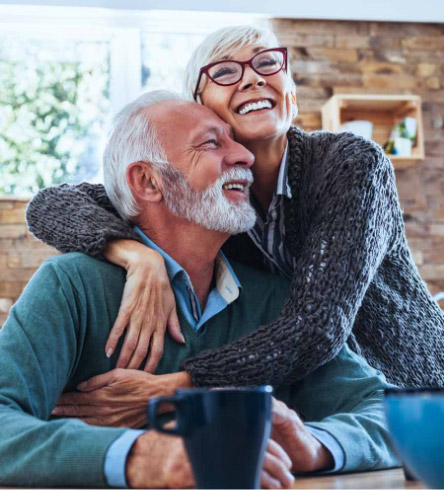 Older couple smiling and embracing - restorative dentistry